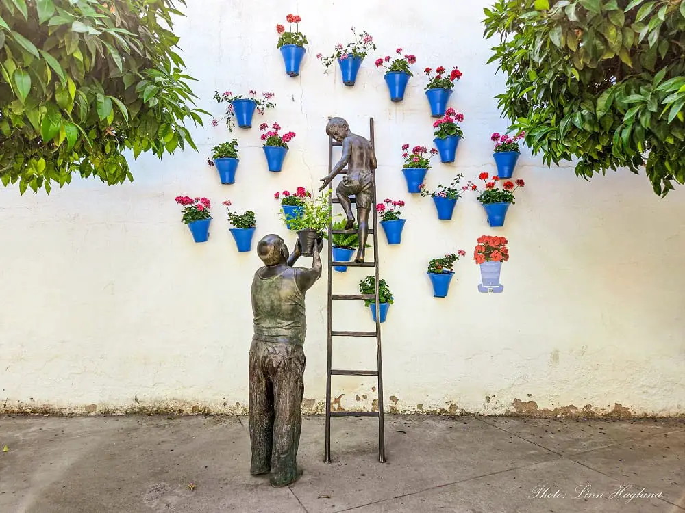 day trip to cordoba - statue of grandpa and grandson watering pot plants