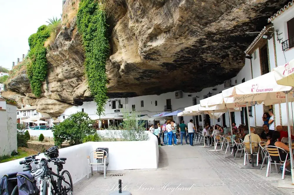 restaurants built into the rock that hangs over the street giving natural shade