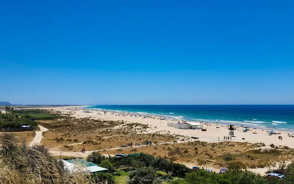 Views of a large beach near Seville Spain, Conil de la Frontera beach, with people sunbathing.