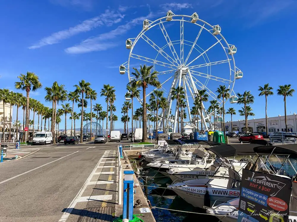 Ferris wheel on a marina with boats for rent in the water - best things to do in Benalmadena Spain