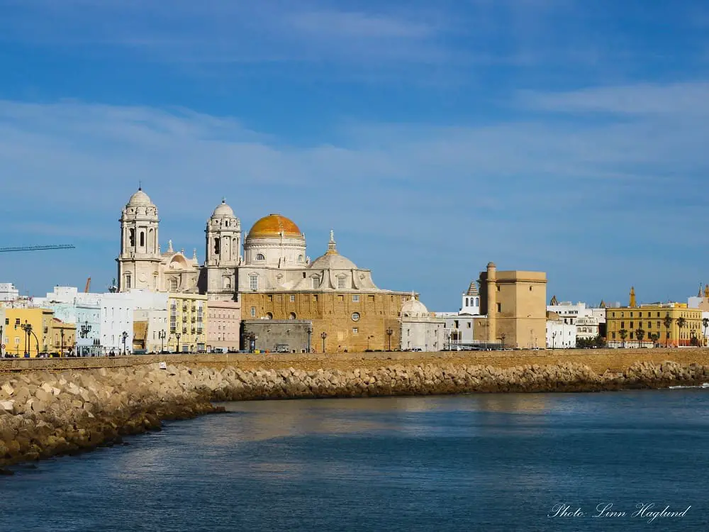 The city of Cadiz seen from the sea with Cadiz Cathedral's golden dome in the center.