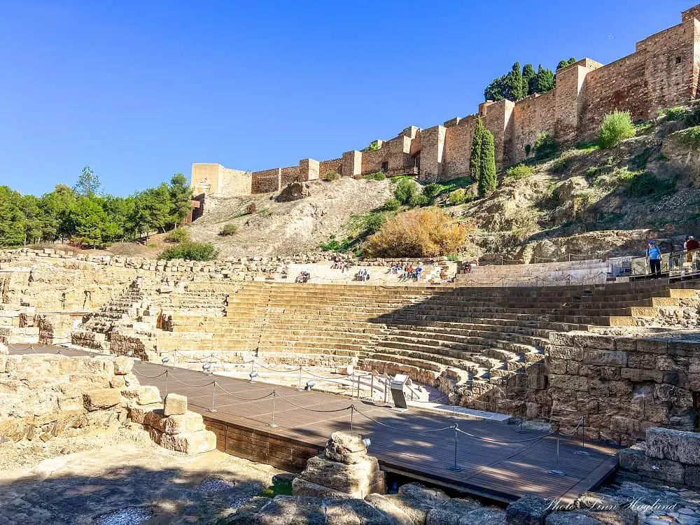 The ruins of the Roman Theater in Malaga with the Moorish walls of the Alcazaba above it.
