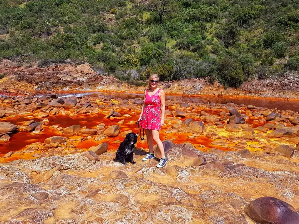 Me and my dog standing by the red river of Rio Tinto Huelva Andalucia.
