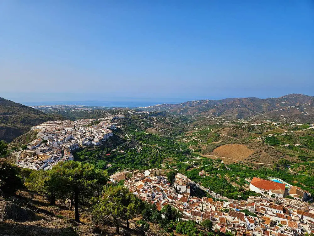 Views from El Castillo Frigiliana of the village, surrounding forest, and the deep blue coast at the far end.