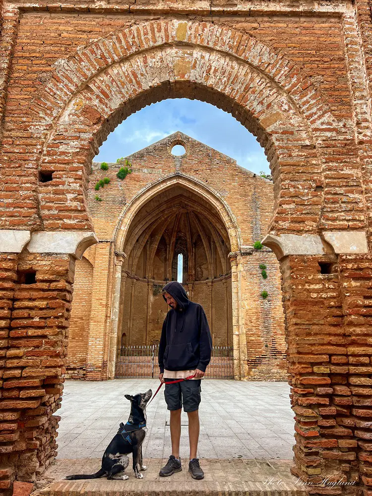 Mohammed and Atlas standing in an arab door with the ruins of a church behind them in Niebla Spain.