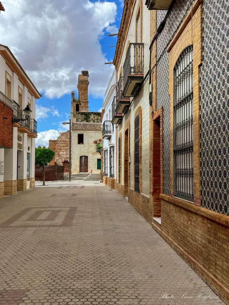 Street in Niebla with tiled housewalls  leading to a church.