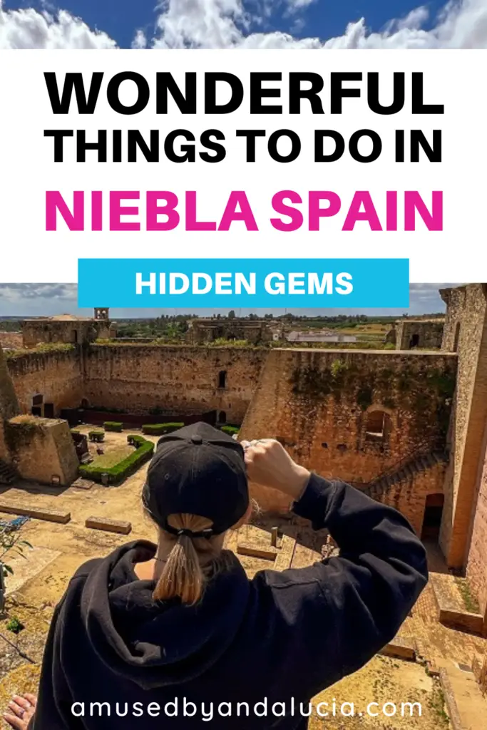 Pinterest image of me looking out at Niebla castle with overlay text saying; "Wonderful Things To Do in Niebla Spain."