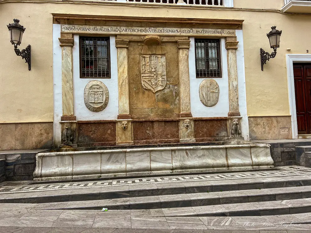 Fountain in Baza with marble columns and lionheads.