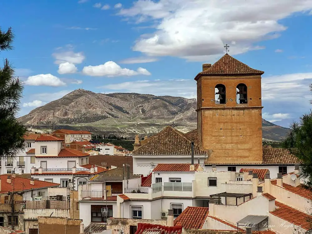 Views of Baza and a clock tower with mountains in the background.